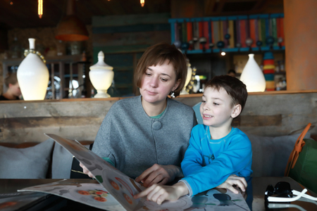 Mother and her son choosing dish in restaurantの写真素材