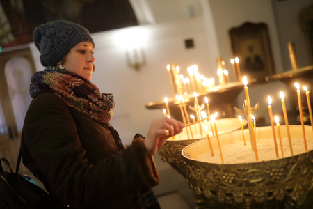 Woman with candles in an orthodox churchの写真素材