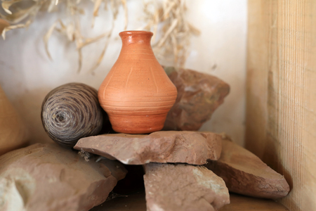 Clay pot on stones in wooden shelfの写真素材