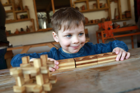 Kid playing with wooden puzzle at tableの写真素材