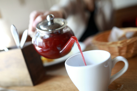 Person pouring fruit tea in the restaurantの写真素材