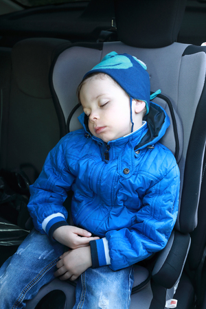 Portrait of child sleeping in car seatの写真素材