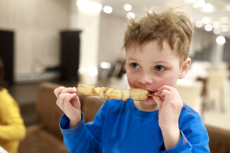 Hungry kid eating kebab in the restaurantの写真素材