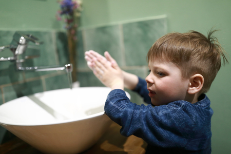 Child washes his hands in a restroomの写真素材