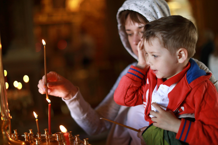 Mother and son put candles in the Russian Orthodox Churchの写真素材