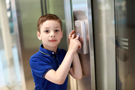 Child calls elevator in a shopping centerの写真素材