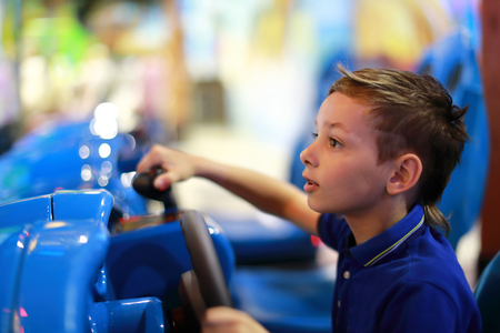 Boy playing car simulator in amusement centerの写真素材