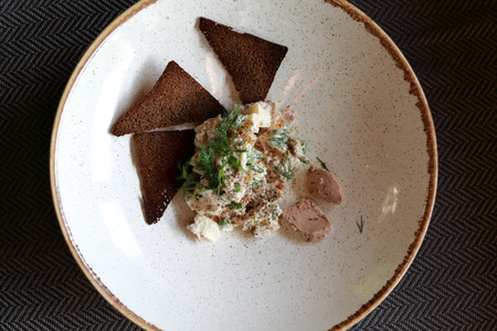 Cod liver with bread on plate in restaurant