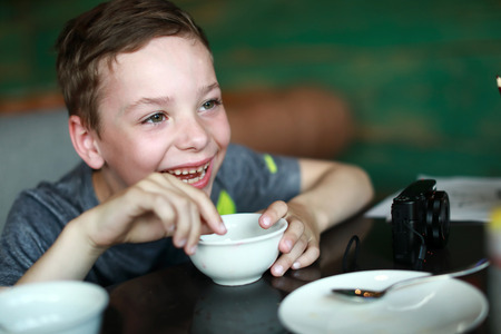 Happy child drinking tea in a restaurant