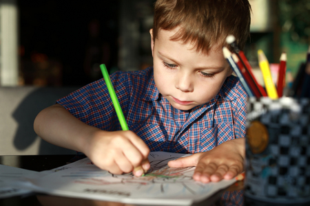 Kid drawing with pencil in a cafeの写真素材
