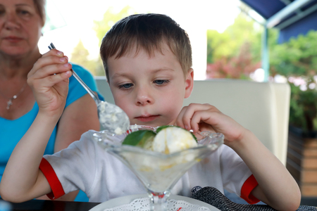 Boy eating ice cream in a restaurantの写真素材
