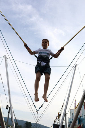 Portrait of child jumping on bungee trampolineの写真素材