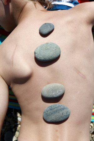Row of pebbles on back of childの写真素材