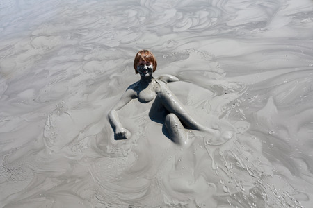 Portrait of woman sitting in mud pond