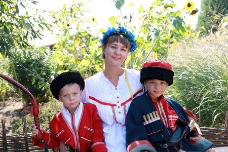 Mother and sons in Cossack costumes in backyard