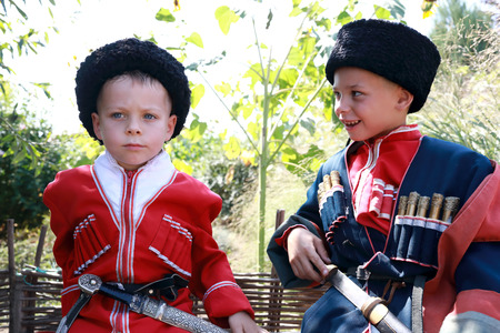 Portrait of brothers in Cossack costumes in backyardの写真素材