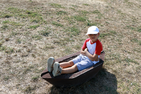 Child sitting in the trough in summerの写真素材