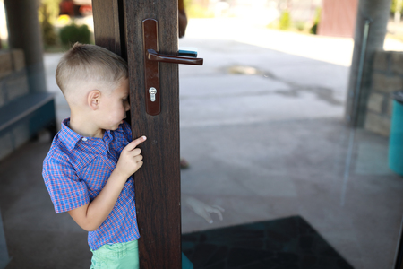 Child opening mirrored front door at hotelの写真素材