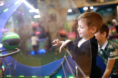 Child throws ball into ring on playgroundの写真素材