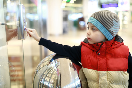 Child calling an elevator in a mallの写真素材