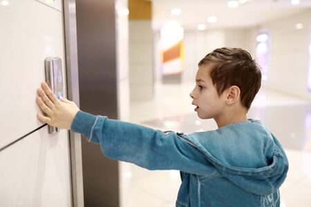 Child calls elevator in a shopping center