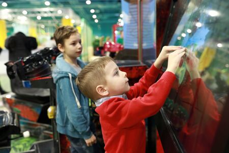 Child plays game on touchscreen in entertainment parkの写真素材