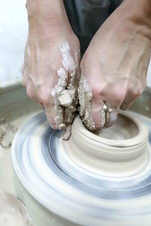 Potter teaches child pottery in the workshop