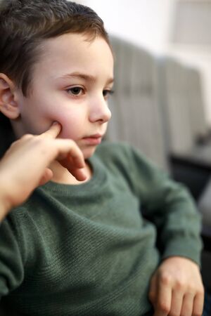 Pensive kid watching a performance in a theaterの写真素材