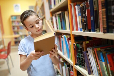 Portrait of child choosing book in library