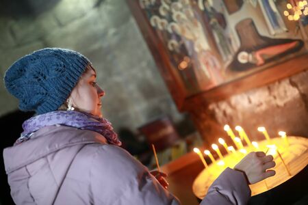 Woman holding candle in Georgian Orthodox churchの写真素材