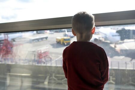 Child waiting for flight in departure lounge at airport