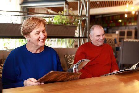 Portrait of senior couple with menu books in restaurant