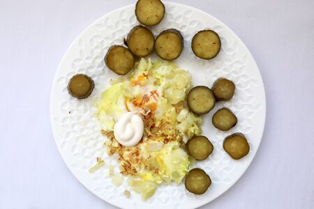 Scrambled Eggs with pickles on white plateの写真素材