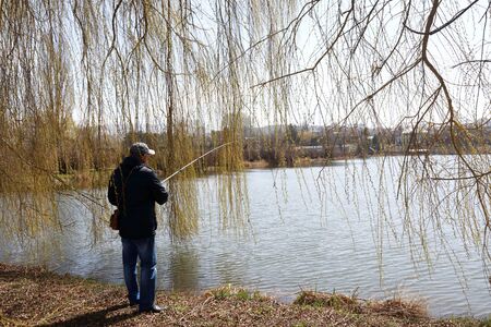 Man fishing on lake in spring, Kislovodsk, Russiaの写真素材