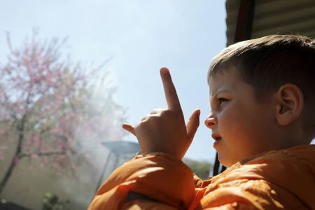 Child making finger gun outdoor in spring