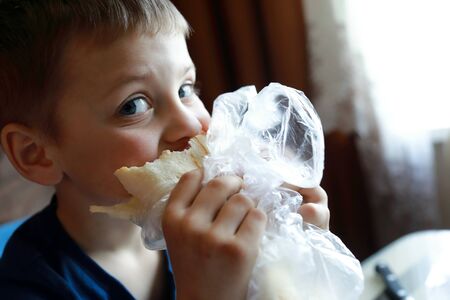Child eating pie in kitchen at homeの写真素材