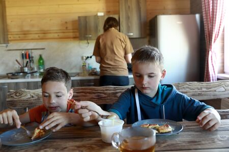 Kids eating pancakes with condensed milk at homeの写真素材
