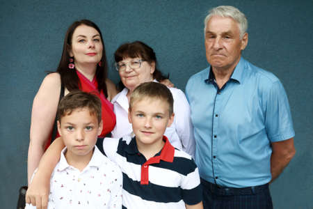 Portrait of family on blue cement wall backgroundの写真素材