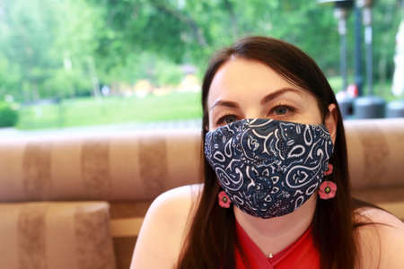 Woman in Medical Protective Face Mask on terraceの写真素材