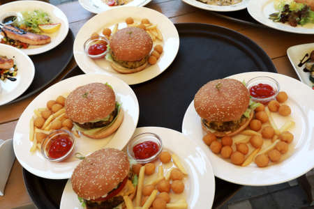 Plates with burgers on tray in restaurantの写真素材