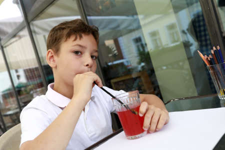 Kid drawing with pencil on terrace of restaurant