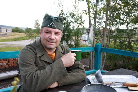 Portrait of man in uniform of Wehrmacht soldier drinking tea