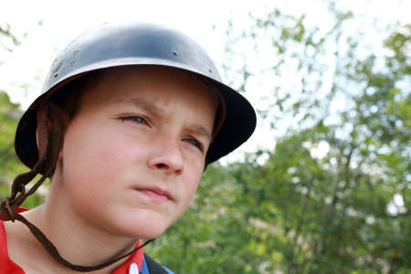 Portrait of boy in old military helmet