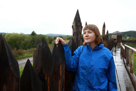 Woman next to wooden palisade of viking village in summerの写真素材