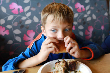 Thinking child eating pie in a restaurant