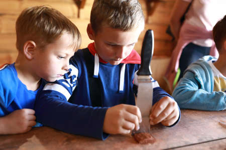 Children making mascot with runes in workshop