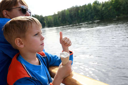 Boy eating ice cream on deck of passenger shipの写真素材