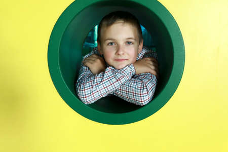Portrait of kid in round hole in playgroundの写真素材