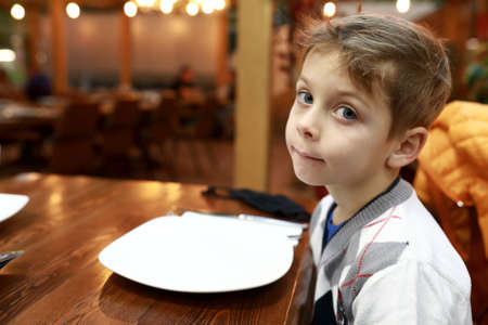 Portrait of pensive child in a restaurantの写真素材