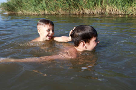 Two kids swimming in lake, Krasnodar region, Russia